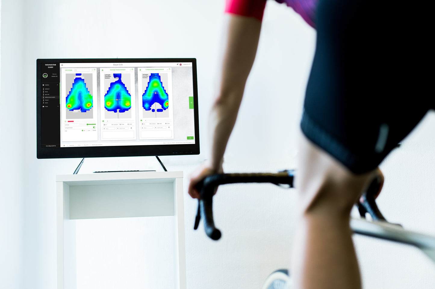 Biker in front of display with Velometrik pressure mapping software for bike fitting